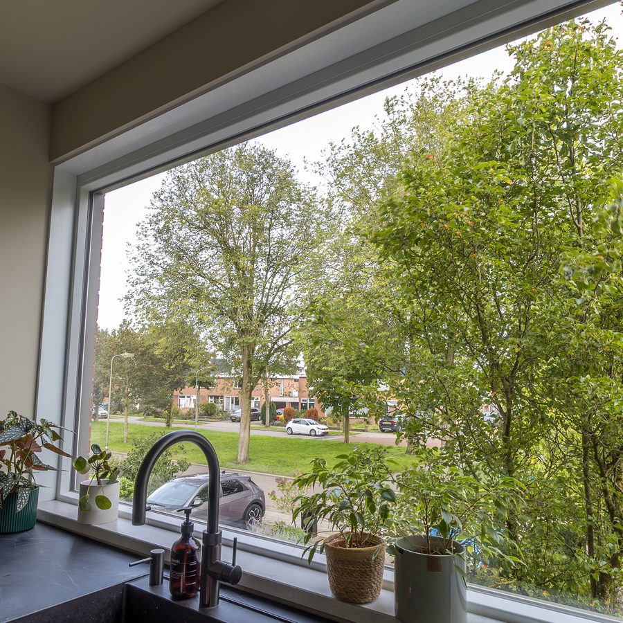 Keukenraam van kunststof met uitzicht op bomen