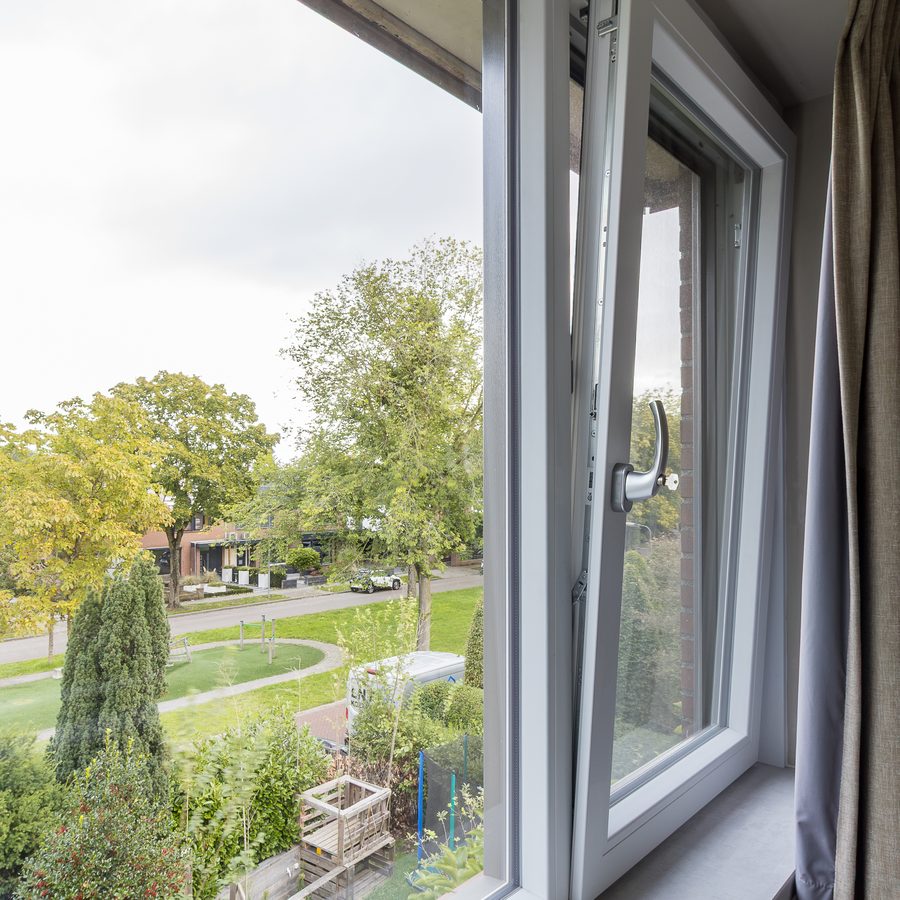 Kunststof kozijn met uitzicht op een speeltuin