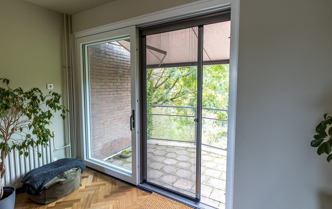 Rustige woonkamer met kunststof schuifpui naar het balkon