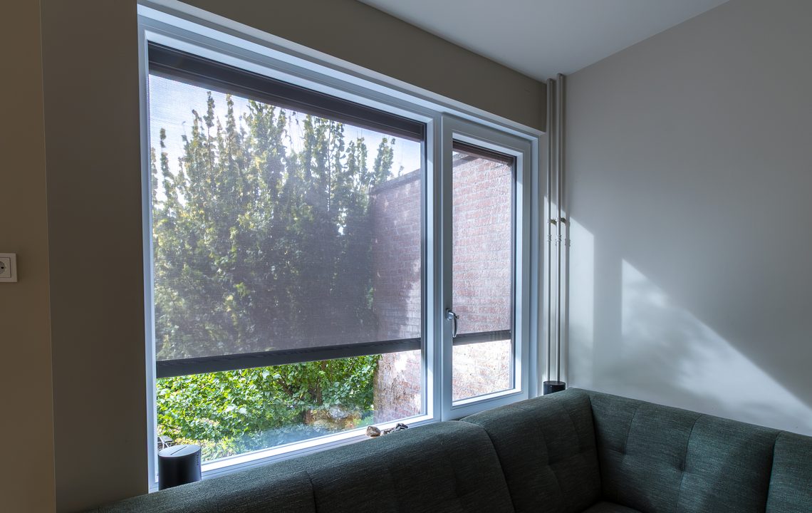 Kunststof kozijn met screen en bankstel in de woonkamer